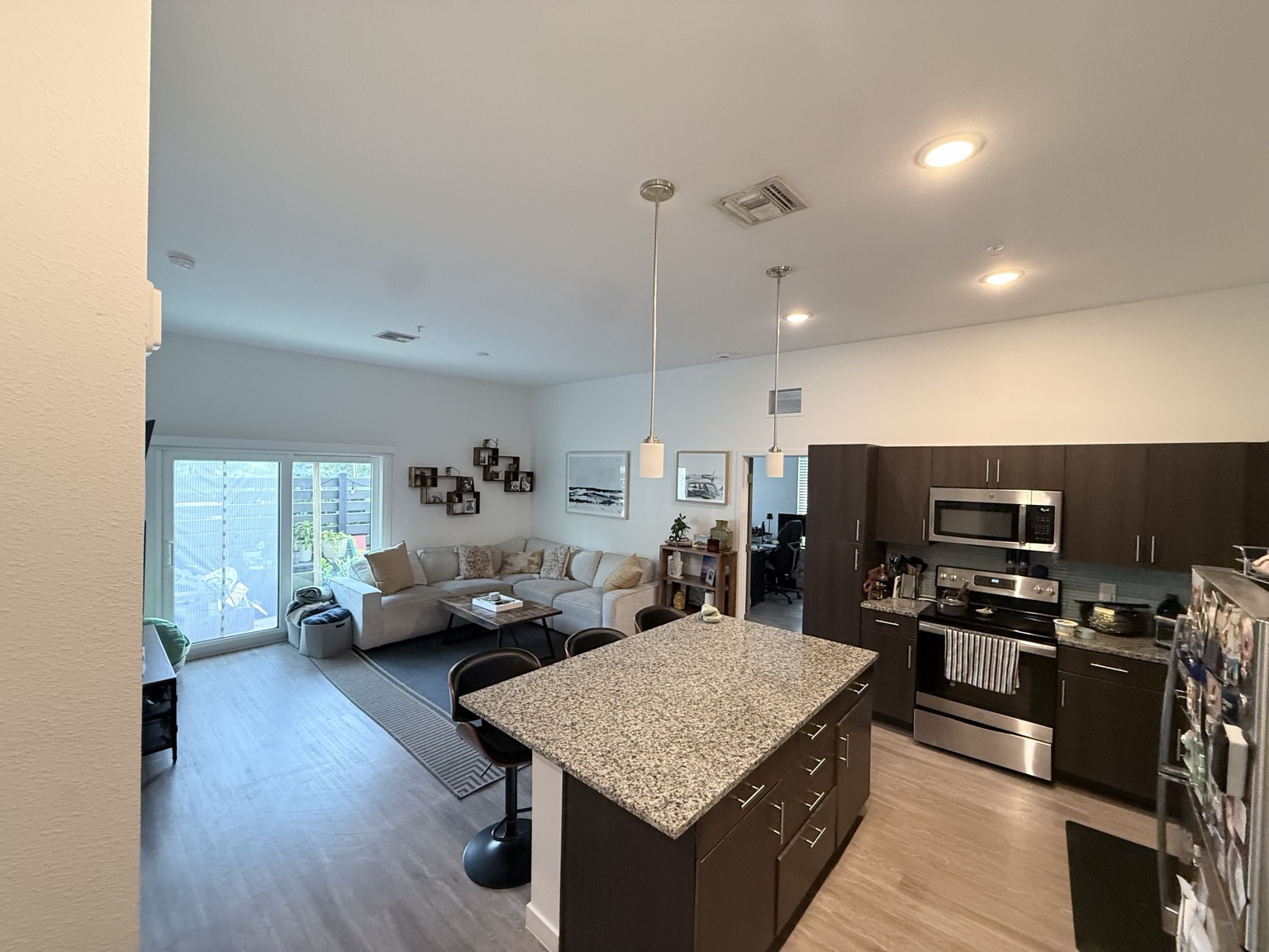 The same kitchen and living area after cleaning, with clear counters and tidy floors