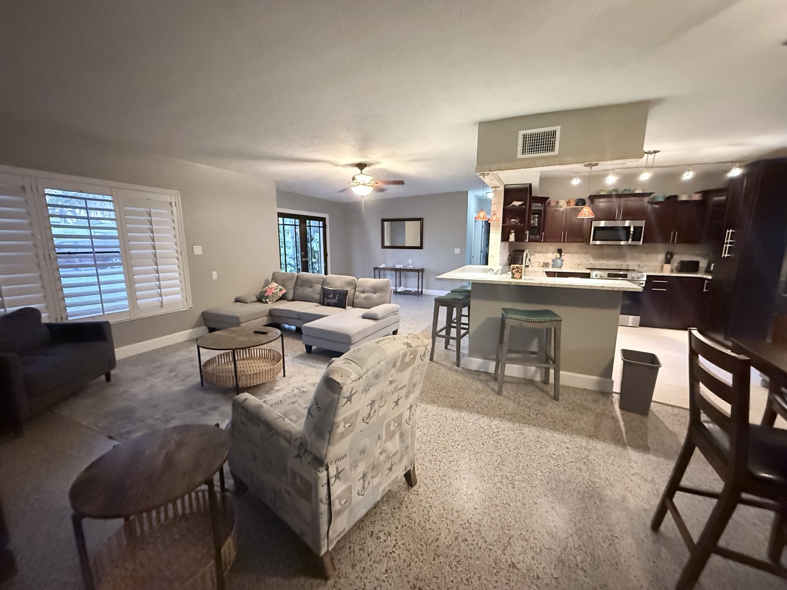 The same living, dining, and kitchen area after cleaning, with clear surfaces and tidy floors