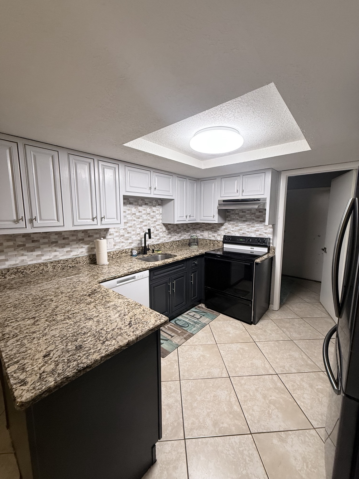 Kitchen after post-construction cleaning, with clean floors, appliances, and clear countertops